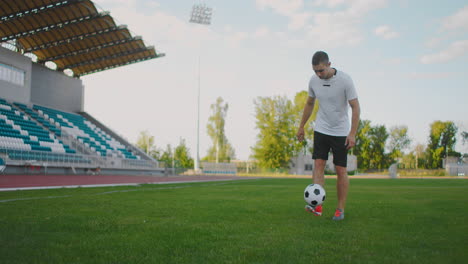 A-man-on-a-football-field-in-slow-motion-in-sports-equipment-bounce-a-soccer-ball